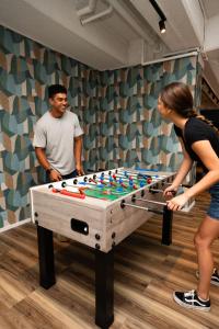 two people standing next to a large pool table at Haka House Auckland City in Auckland