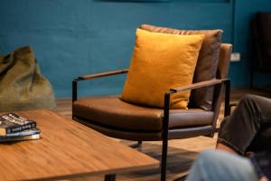 a chair with a yellow pillow sitting next to a table at Haka House Auckland City in Auckland