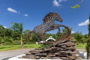 Eine Statue eines Pferdes, das über einen Haufen Steine hüpft. in der Unterkunft El Lugar in Tigre