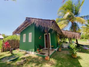 a green cottage with a thatched roof at Bangalô Verde Recanto Uaná - 280m praia Tatuamunha in Maceió