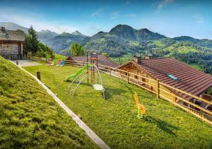 a playground in a field with mountains in the background at Chalet Caramel - Les Congères in Manigod