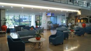 un vestíbulo con sillas y mesas azules y TV en Crown Towers - Private Apartment, en Gold Coast