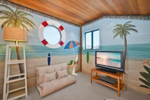 een woonkamer met een televisie en een schilderij van een strand bij 4 bedroom Home in Quiet Neighborhood near Beach in Newport Beach