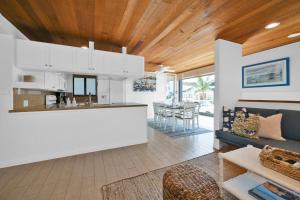 een keuken en een woonkamer met witte muren en houten plafonds bij 4 bedroom Home in Quiet Neighborhood near Beach in Newport Beach