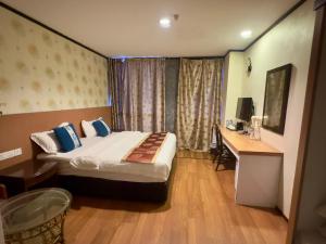 a hotel room with a bed and a desk at Suan Bee Hotel@Sutera in Skudai