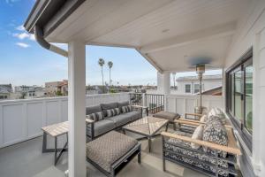 een patio met een bank en stoelen op een balkon bij 4 Bedrooms in BRAND NEW Luxury built Home walk to the beach in Newport Beach