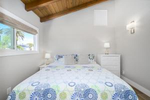 紐波特海灘的住宿－Brand New Modern Home by the Beach with Patio & BBQ，一间卧室配有一张带蓝色和白色床单的床。