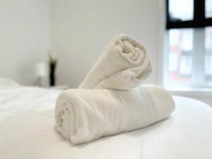 una pila di asciugamani bianchi su un letto di Superb 2 BedR Haven 2mins from Frontenac Metro! a Montréal