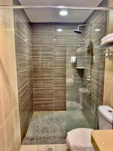 a bathroom with a glass shower with a toilet at Suan Bee Hotel@Sutera in Skudai