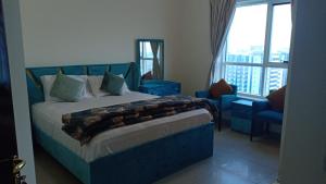 a bedroom with a blue bed and a blue chair at 22 R3 Luxury Room in a 4-bedroom apartment with private washroom outside the room ### 22 R3 غرفة فاخرة في شقة 4 غرف نوم مع حمام خاص خارج الغرفة ### in Ajman 
