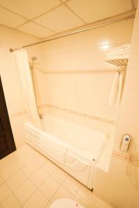 baño blanco con bañera y aseo en Hoa Binh 1 Hotel, en Long Xuyen