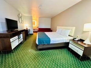um quarto de hotel com uma cama e uma televisão de ecrã plano em Studio 6 Suites Flagstaff AZ em Flagstaff