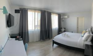 Un dormitorio con una gran cama blanca y una ventana en Hometel Suites en Los Ángeles