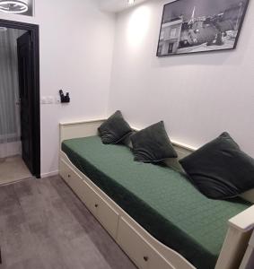 a bed with black pillows on it in a room at Bright small studio Paris Saint Ouen in Saint-Ouen