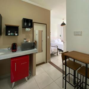 a kitchen with a red cabinet and a dining room at Quinta Vogrande no bairro de Águas Santas entre Tiradentes e São João Del Rey in Tiradentes +25 photos