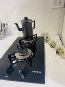 a tea kettle on a stove in a kitchen at Flat Acolhedor Um encanto em Umuarama in Umuarama