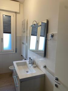 a bathroom with a sink and a mirror and a toilet at SWEET HOME in Modena
