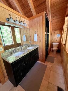 ein Bad mit 2 Waschbecken und einem WC in einer Hütte in der Unterkunft Sunset Point on Lake Keowee in Six Mile