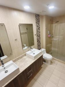 La salle de bains est pourvue d'un lavabo, de toilettes et d'un miroir. dans l'établissement Panama's Paradise Playa Blanca Ocean & Pool View, à Río Hato