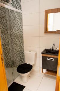a bathroom with a toilet and a shower and a sink at Apartamento Primavera in Boituva