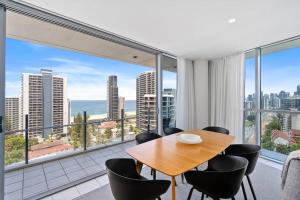 a dining room with a table and chairs and a large window at Spectacular Views from Wyndham Apartment in Gold Coast