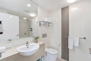 a white bathroom with a sink and a toilet at Spectacular Views from Wyndham Apartment in Gold Coast