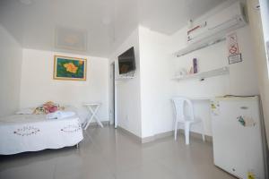 Habitación blanca con cama y nevera. en Posada Dima Cresida, en San Andrés