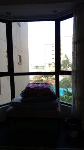 a bed in a room with a large window at Melaka Family Beachfront in Kampong Lereh