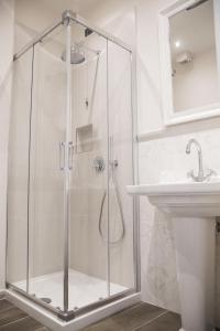 a shower with a glass door next to a sink at Tornabuoni View in Florence