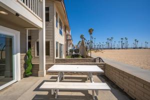 uma mesa de piquenique ao lado de uma casa ao lado da praia em Giant Beachfront Home with Parking near the Pier em Newport Beach