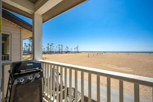 - un barbecue sur la terrasse couverte à l'avant d'une maison de plage dans l'établissement Stunning Oceanfront Retreat in Newport Beach, à Newport Beach