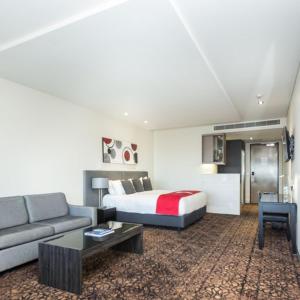 a hotel room with a bed and a couch at Calamvale Hotel Suites and Conference Centre in Brisbane