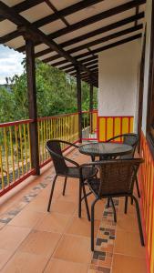 a patio with two tables and chairs on a deck at Cabañas Nazak Lago 1 in Pereira