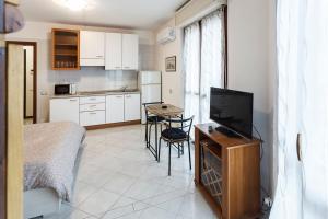 uma sala de estar com televisão e uma cozinha em Loft alto con vista su Città Alta em Bérgamo mais 9 fotografias