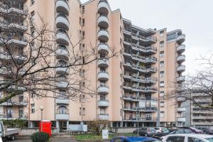 um grande edifício rosa com carros estacionados em frente em Loft alto con vista su Città Alta em Bérgamo