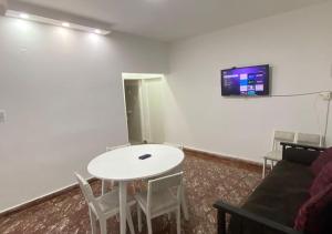 a room with a white table and a tv on a wall at Casa con cochera in Villa Krause