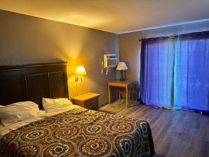 una camera con letto e tende blu di Clintonville Motel a Clintonville