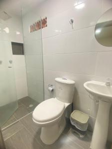 Baño blanco con aseo y lavamanos en 23 COMODO APARTAMENTO CON BALCON EN LAURELES ESTADiO, en Medellín