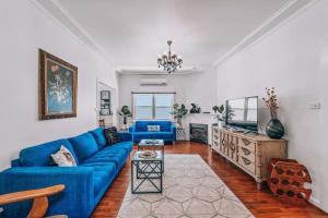 un soggiorno con divano blu e TV di Newly Renovated Victorian Townhouse In Bendigo CBD a Bendigo