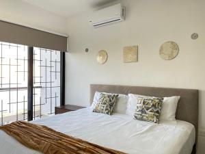 une chambre avec un lit avec des draps blancs et des oreillers dans l'établissement Kaab: Exclusividad y confort en un oasis vacacional con piscina, à Mérida 15 autres photos