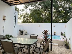 un patio avec une table et des chaises et une piscine dans l'établissement Kaab: Exclusividad y confort en un oasis vacacional con piscina, à Mérida