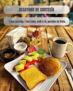 un plato de comida con tostadas y fruta y una taza de café en Hotel el Descanso Barrio del Artista, en Puebla