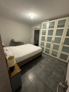 - une chambre avec un lit, une table et des armoires dans l'établissement Appartement T3 proche centre ville, à La Teste-de-Buch