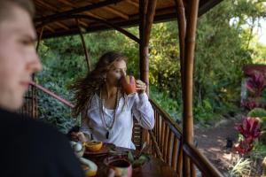 a woman sitting at a table drinking from a red cup at Maui Eco Retreat in Huelo