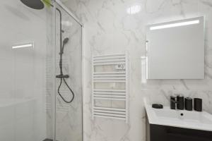 a bathroom with a shower and a sink and a mirror at 864 Suite Iris - Superb apartment in Montreuil