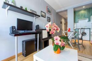 a living room with a vase with pink flowers on a table at One bedroom property with wifi at Madrid in Madrid