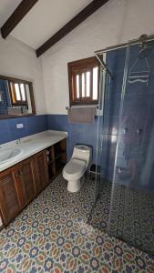 uma casa de banho com um WC, um chuveiro e um lavatório. em Cabañas Nazak Lago 1 em Pereira