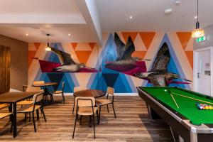 a pool table in a restaurant with birds on the wall at Haka House Christchurch in Christchurch