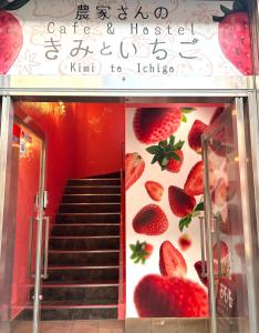a staircase with strawberries on the wall of a building at Cafe&Hostel きみといちご in Osaka