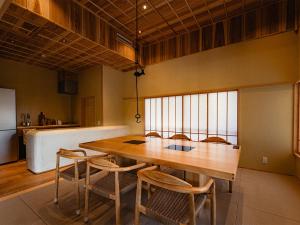 a kitchen with a wooden table and chairs at Kominakayado LOOF Yuraginoie in Iwase